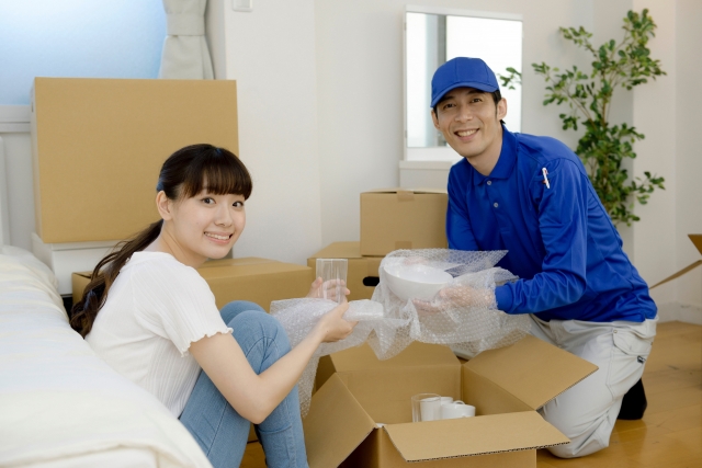 引越し作業中に作業員と話をする女性
