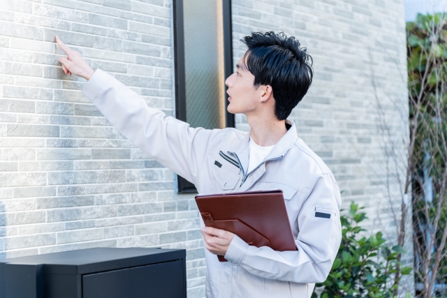 外壁を調査する男性