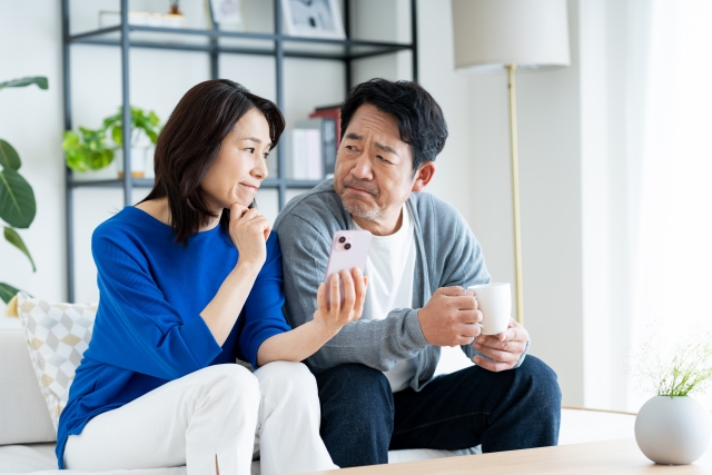 スマホを手に悩む夫婦